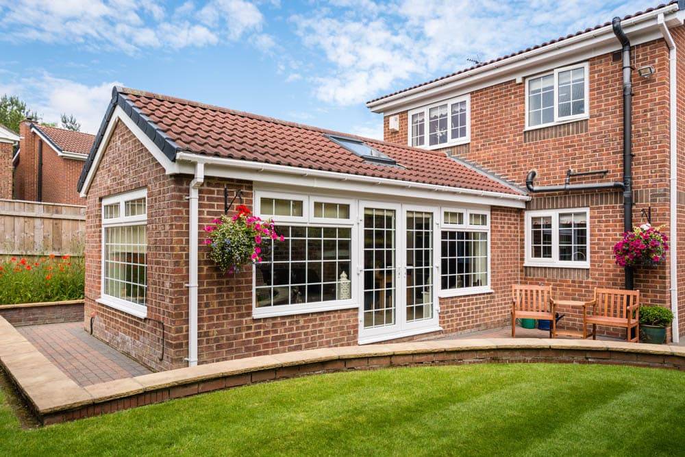 Modern Sunroom or conservatory extending into the garden, surrounded by a block paved patio.